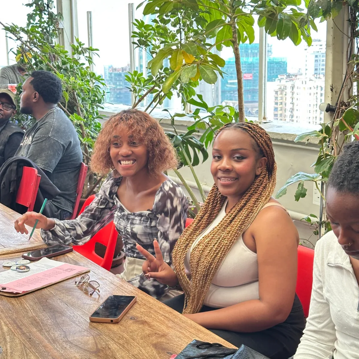 Guests smiling around the rooftop table with the Nairobi skyline behind them