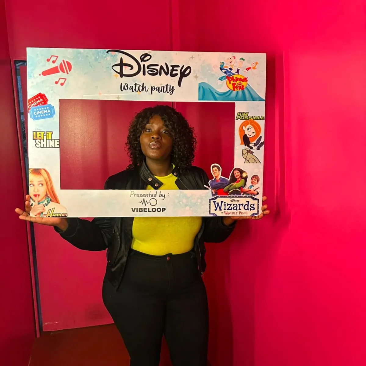 Guest posing with the photo frame against the deep pink wall